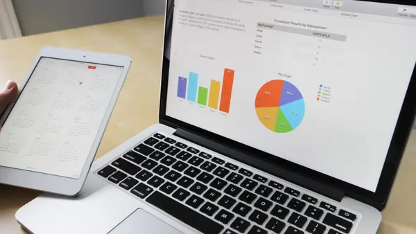 Notebook con gráficos financieros sobre un escritorio