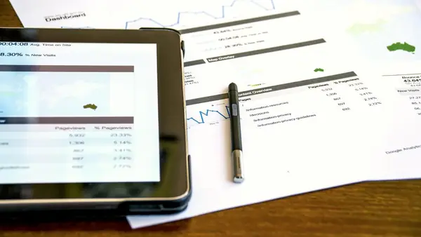 Tableta con informes financieros y documentos de cierre