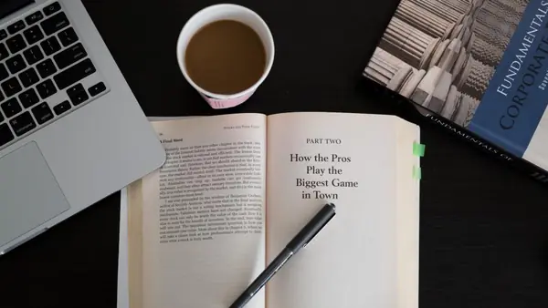 Notebook, libro y café para planificar el presupuesto