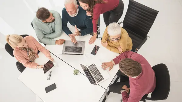 Equipo de trabajo analizando riesgos alrededor de una mesa